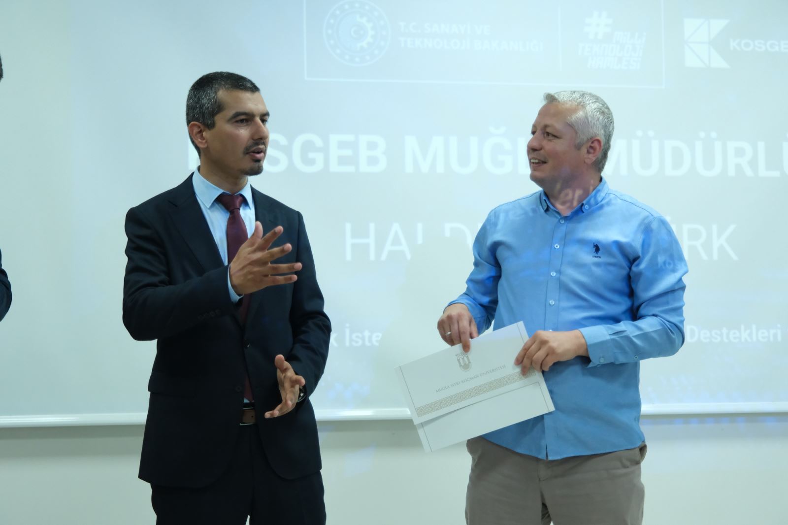 At the end of the event, as a certificate of appreciation is presented to the speaker, two participants are pictured together on stage.